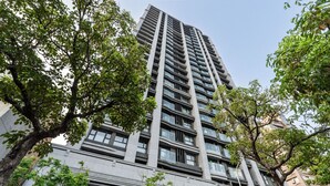 Um edifício alto com várias varandas e um design arquitetônico moderno.