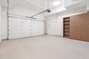 A room with a large white door, a ceiling-mounted projector, and a wooden wardrobe. - Newly Built 3BR Townhome | Rooftop Patio & Garage (Langley)