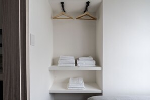 A white wall with two wooden hangers and three white shelves. - Blueground | Zhengshou District, balcony, nr park (TPE-1) (Taipei)