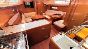 A compact galley with a stove, sink, and seating area. - Sun-Kissed Sailing Adventure in Zadar, Croatia (Bibinje)