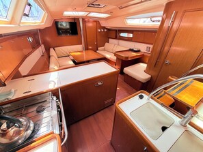 A compact galley with a stove, sink, and seating area. - Sun-Kissed Sailing Adventure in Zadar, Croatia (Bibinje)