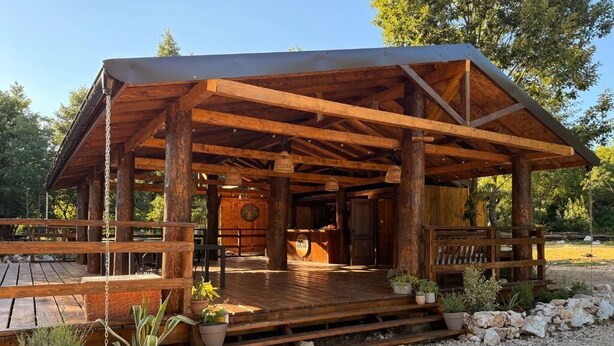 A wooden cabin with a porch, a wooden deck, and a gravel path. - Bungalow with Patio (Rvaši)