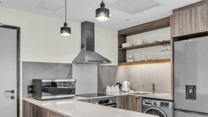 A modern kitchen with a built-in microwave, stove, sink, and stainless steel refrigerator. - Softstay, Foreshore Cape Town CBD (Cape Town)