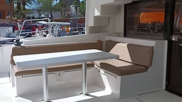 L'intérieur d'un bateau, avec une table blanche et des sièges rembourrés.