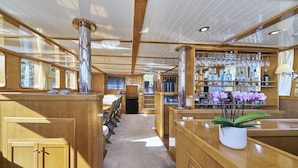 A bar area with wooden paneling, a seating area, and a potted plant. - Sun-Kissed Sailing Adventure in Split, Croatia (Split)