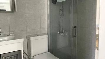 Habitación cuádruple Deluxe, balcón, vistas al jardín | Baño | Ducha, secador de pelo, zapatillas y toallas