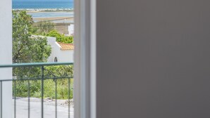 A room with a view of the sea, a balcony with a railing, and a framed picture on the wall. - FU1 in Moncarapacho With 6 Bedrooms and 6 Bathrooms (Olhao)