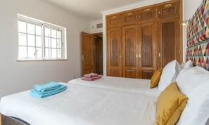 Ein Schlafzimmer mit einem großen Bett, einem Holzschrank und einem Fenster.