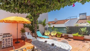 A patio with a table and chairs, a yellow umbrella, and potted plants. - BI1 in Lisboa Ciudad (Lisbon)