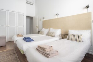 Une chambre d’hôtel avec deux lits, une armoire et une table de chevet.