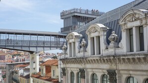 Un bâtiment historique à l’architecture riche et ornée, un pont en arrière-plan et une vue sur le paysage urbain.