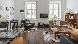 Un salon moderne avec une table basse en verre, un canapé en cuir et une bibliothèque.