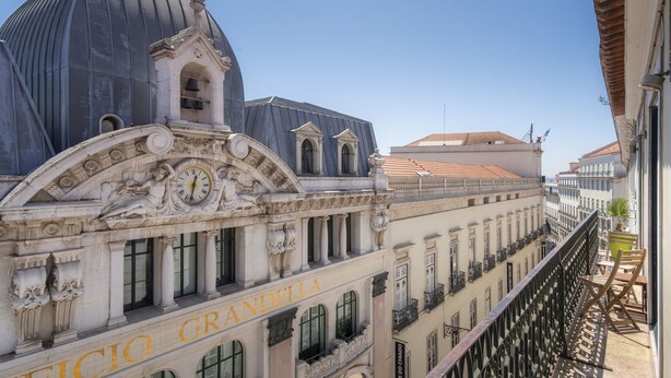 Un edificio con un reloj, un letrero 'ANDELLA' y balcones.