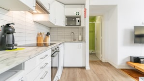 A modern kitchen with white cabinetry, a microwave, a coffee maker, and a sink. - CH8 in Lisboa Ciudad (Lisbon)