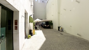 A narrow alleyway with a cobblestone path, a green door, and a small yellow stool. - CH8 in Lisboa Ciudad (Lisbon)