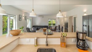 A modern kitchen with a built-in oven, a coffee maker, and a sink. - LA1 in Sesimbra With 5 Bedrooms and 4 Bathrooms (Sesimbra)