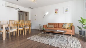 A modern living room with a wooden dining table, chairs, a sofa, and a coffee table. - CH1 in Lisboa Ciudad (Lisbon)