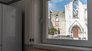 A window view of a historic building with a large arched doorway and a red door. - CH1 in Lisboa Ciudad (Lisbon)