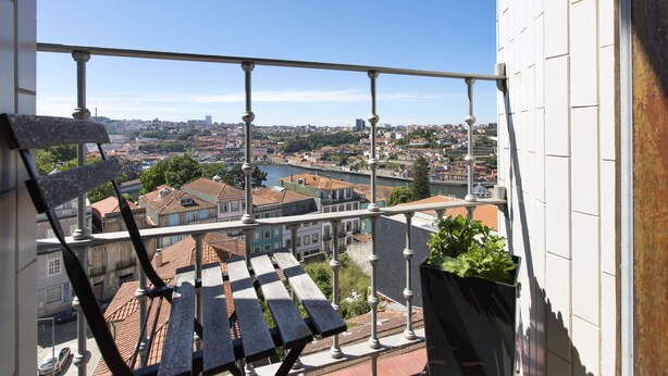 En balkon med udsigt over en by, inklusive bygninger og en flod.