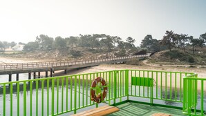 Un puente sobre el agua, un flotador y una barandilla verde.