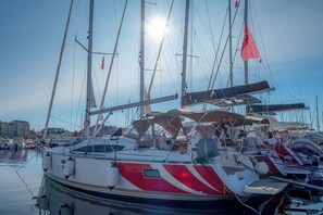 A marina with multiple sailboats docked, some with canopies, and a clear sky above. - Sun-Kissed Sailing Adventure in Zadar, Croatia (Biograd na moru)