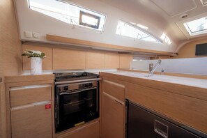 A compact kitchen with built-in appliances, a small sink, and a window for natural light. - Sun-Kissed Sailing Adventure in Zadar, Croatia (Biograd na moru)