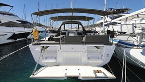 A marina with a white boat featuring a covered deck, a steering wheel, and a small cabin area. - Sun-Kissed Sailing Adventure in Istria, Croatia (Pula)