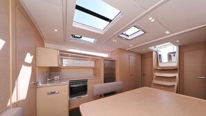 A compact RV interior with a kitchenette, a dining area, and a small seating space. - Sun-Kissed Sailing Adventure in Sibenik, Croatia (Primošten)