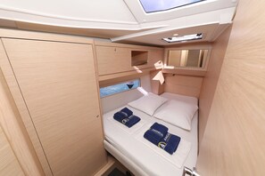 Una cabaña pequeña con cama, un ventanal y un tragaluz.