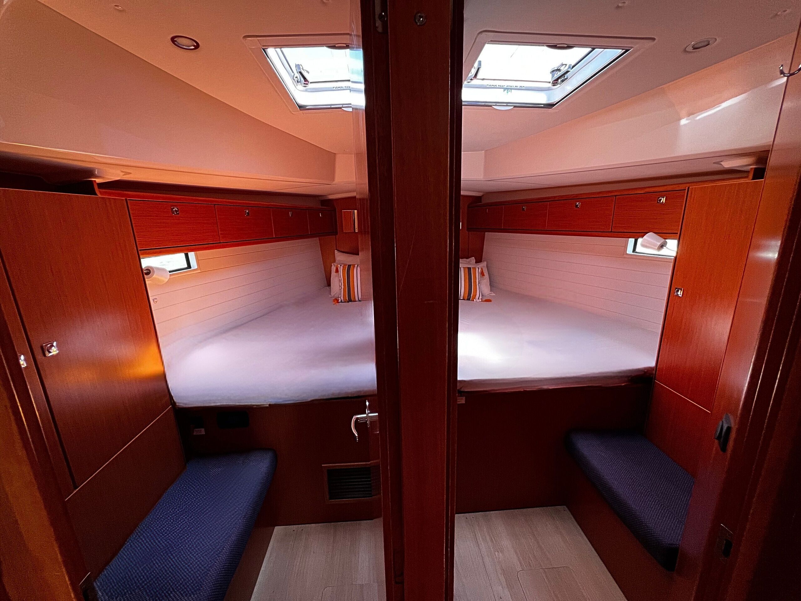 Ein kompaktes Kabinenboot mit zwei Kojen, einem Dachfenster und einer kleinen Sitzecke.