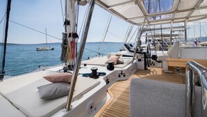 Un pont de yacht équipé de sièges, d’un volant et offrant une vue sur l’eau.