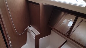 A compact bathroom with a toilet, a small sink, and a shower area. - Sun-Kissed Sailing Adventure in the Sporades Islands from Volos, Thessaly (Volos)