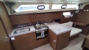 A compact galley with a sink, stove, and small seating area. - Sun-Kissed Sailing Adventure in the Sporades Islands from Volos, Thessaly (Volos)