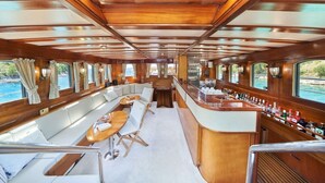 A boat interior with a bar, seating area, and large windows. - Sun-Kissed Sailing Adventure in Split, Croatia (Split)