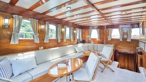 A cabin with a wooden ceiling, large windows, a sofa, and a table. - Sun-Kissed Sailing Adventure in Split, Croatia (Split)