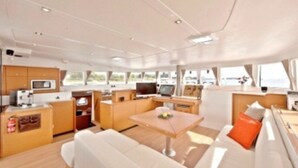 L'intérieur d'un yacht comprenant une cuisine, un coin repas et un espace salon.