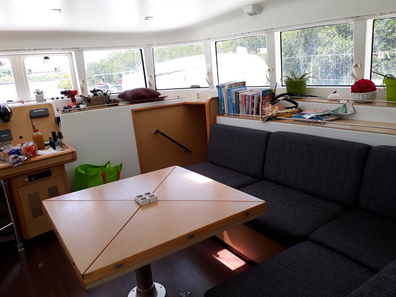 Habitación compacta y bien iluminada con sofá, una mesita y ventana con vistas a zonas verdes.