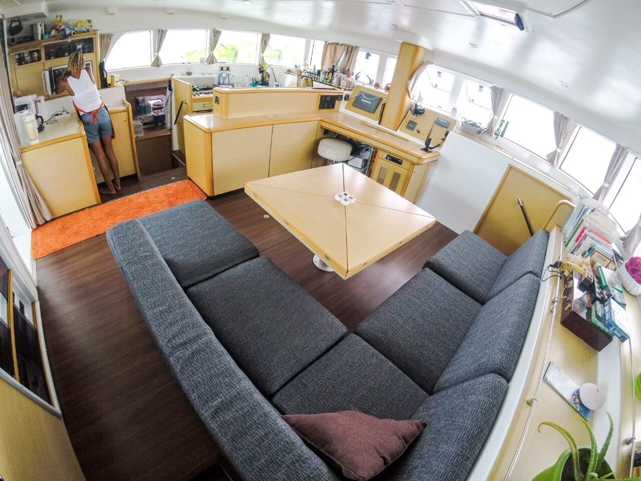 Un espacio habitable compacto con sofá, una mesita y una kitchenette.