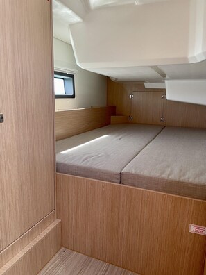 Ein gemütlicher Innenraum mit Etagenbett, kleinem Fenster und Ablagefach.