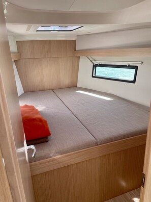 A compact RV interior with a bed, a small window, and a skylight. - Sun-Kissed Sailing Adventure in Islas Baleares, Mallorca (Palma)