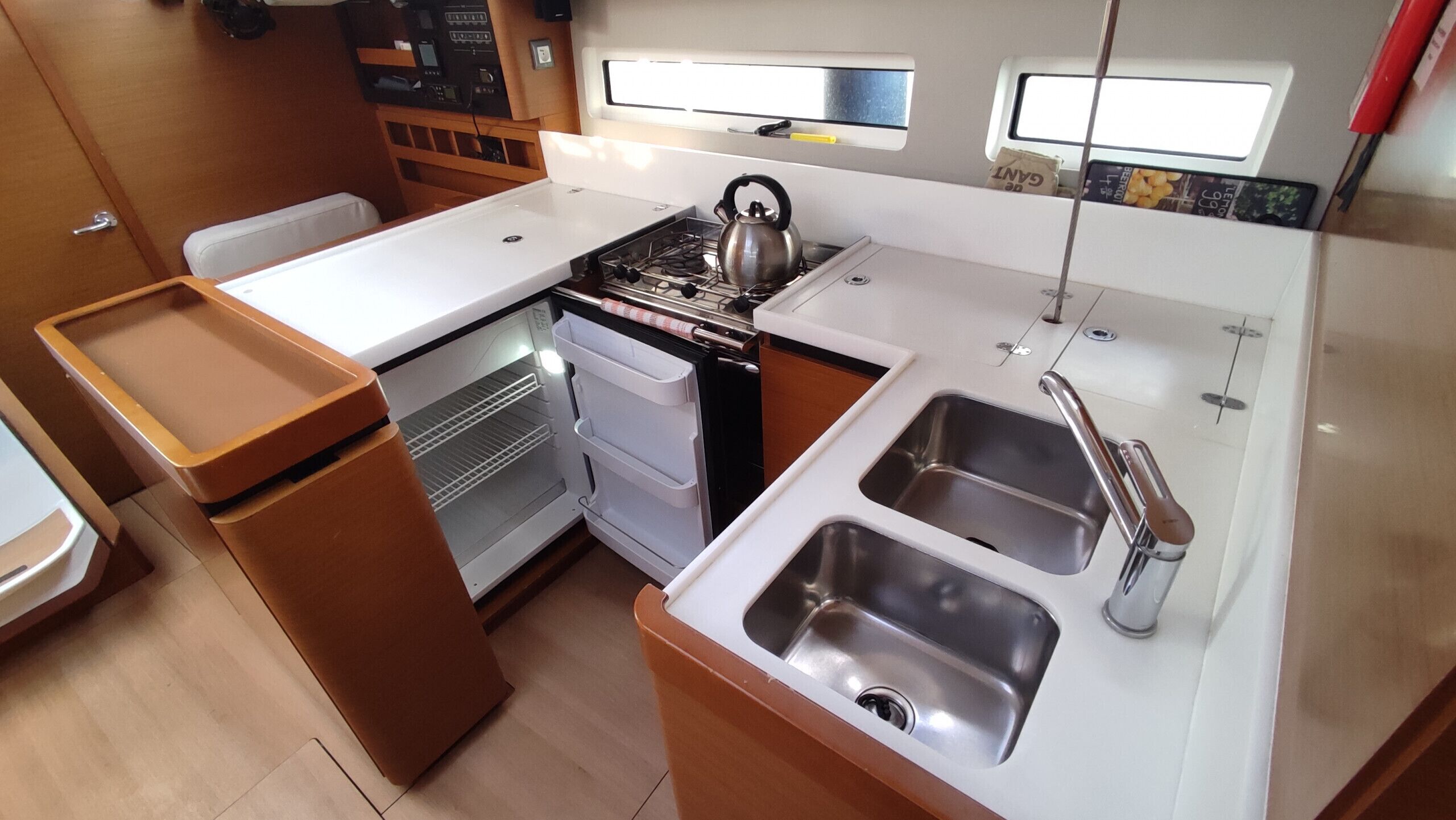 A compact kitchen with a stove, kettle, oven, and two sinks.