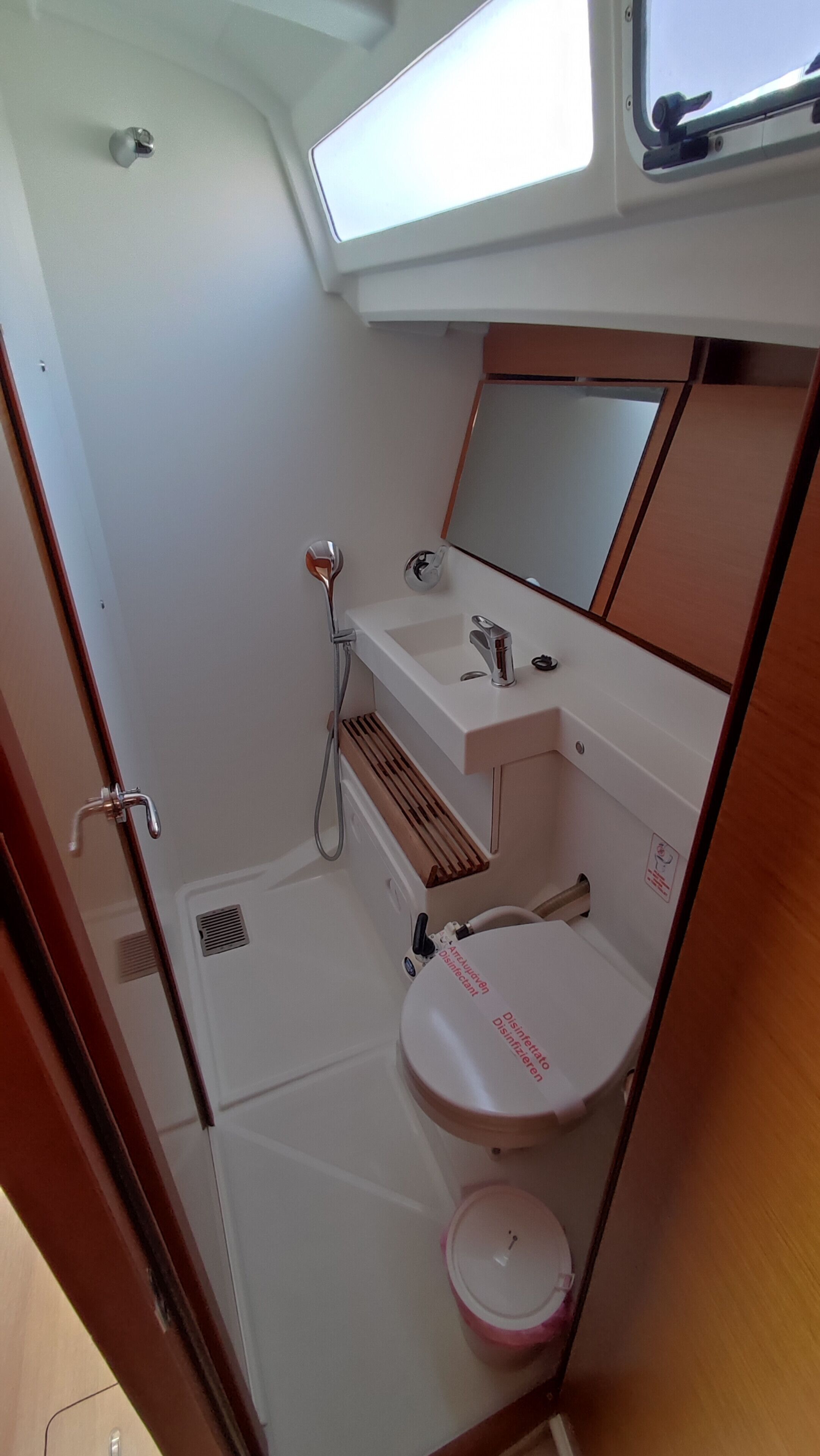 A compact bathroom with a sink, mirror, and shower.