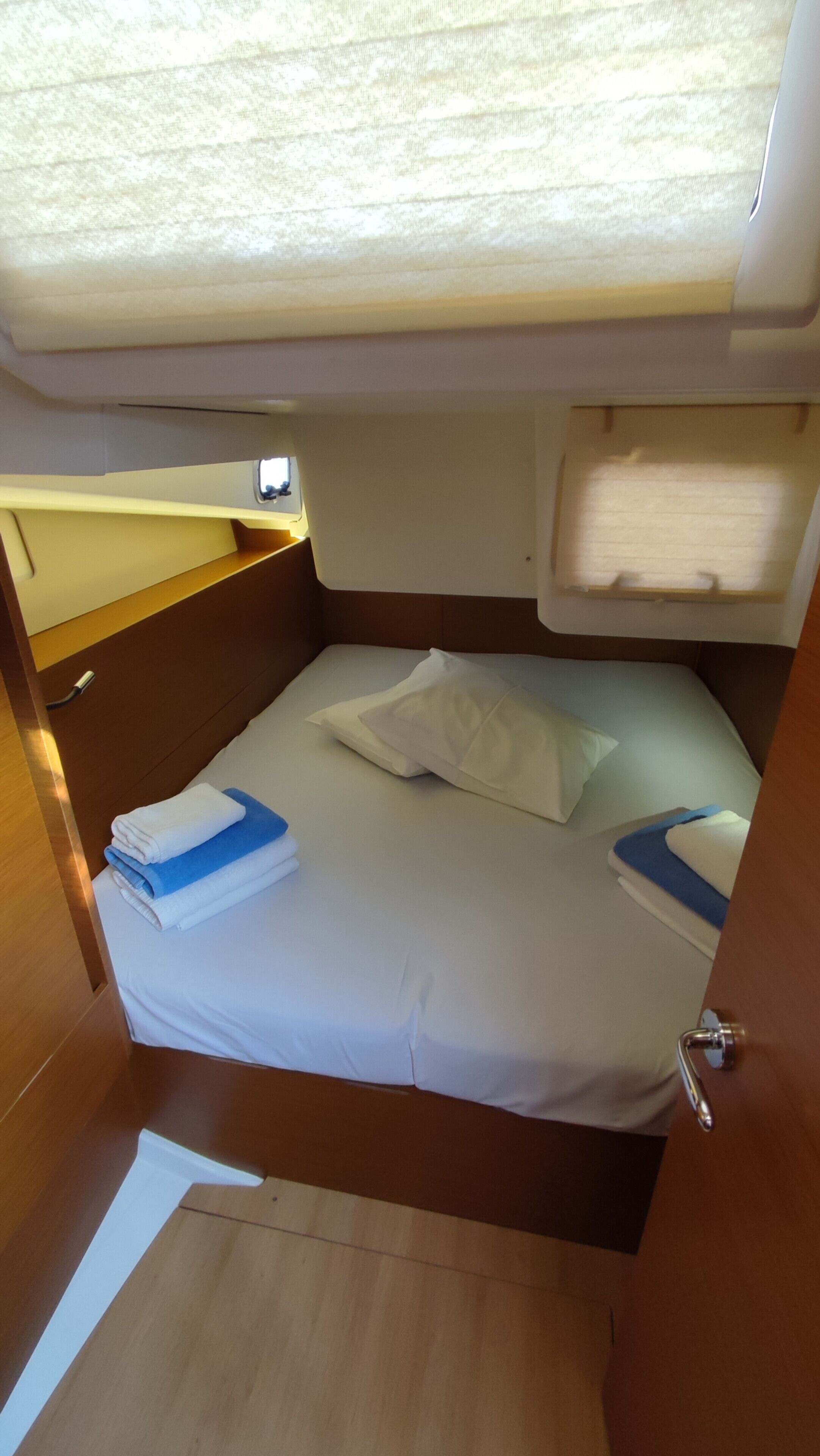 A compact, well-lit cabin with a bed, a small window, and a door.