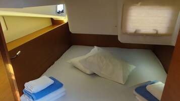 A compact, well-lit cabin with a bed, a small window, and a door.