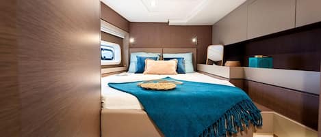 Un dormitorio con cama, tragaluz, mesita de noche y mesilla.