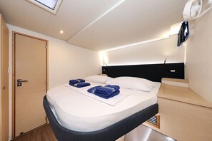 A compact bedroom with a single bed, a bedside table, a headboard, a ceiling fan, and a door. - Sun-kissed Sailing Adventure in Split-Dalmatia, Croatia (Trogir)