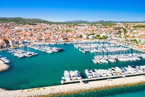 A marina with numerous boats docked, surrounded by a coastal town with red-roofed buildings. - Sibenik Sun and Beach Sailing Extravaganza: A Croatian Coastal Adventure (Vodice)