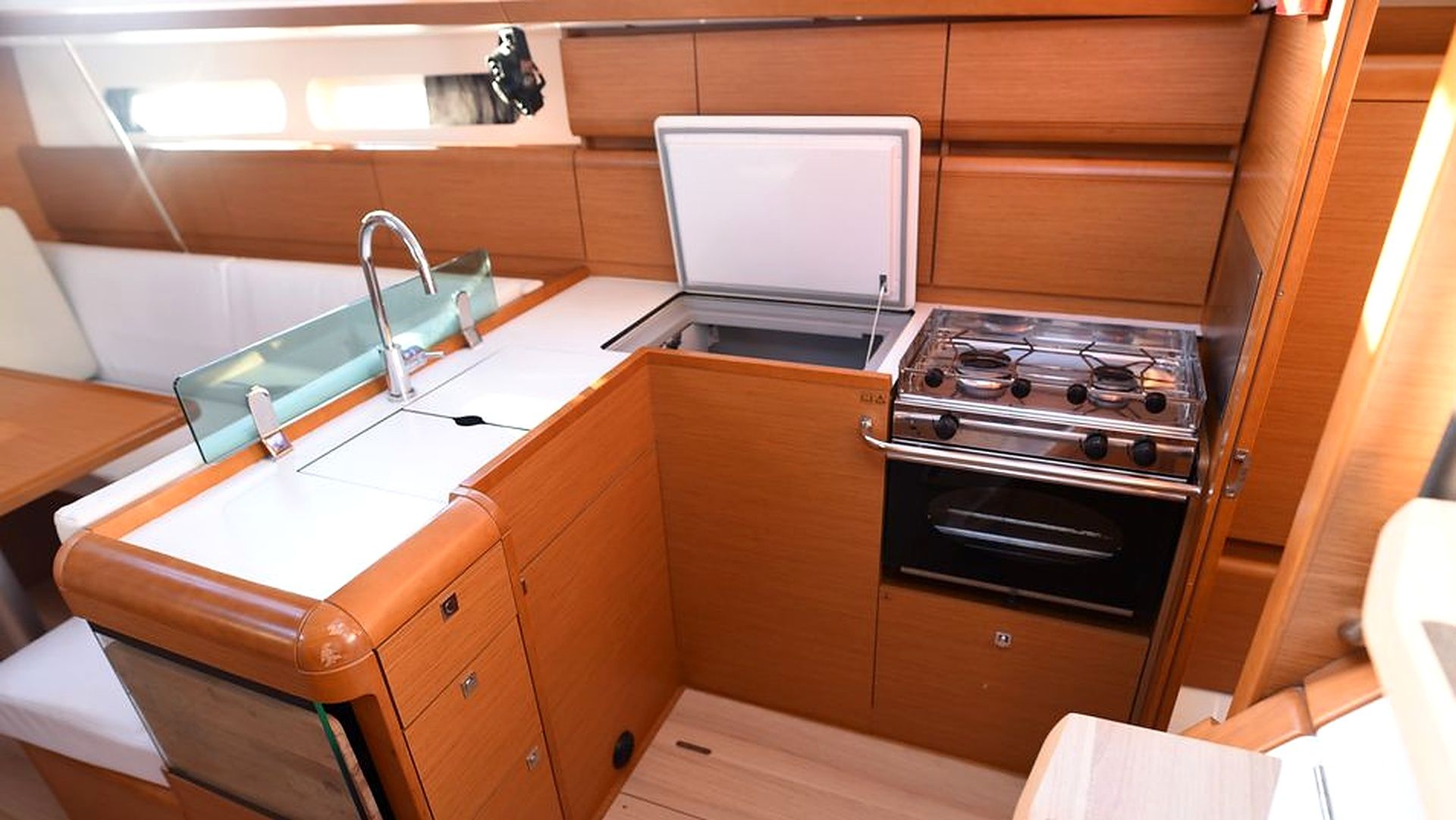 A compact kitchenette with a sink, stove, and storage cabinets.