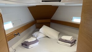 A compact, well-lit cabin with a single bed, a small window, and a wooden door. - Sun-Kissed Sailing Adventure in the Sporades Islands from Volos, Thessaly (Volos)