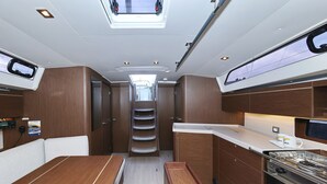 Een compacte keuken met een centraal kookeiland, verlichting erboven en een raam.